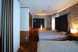a hotel room with two beds and a window at UmisoraHouseうみそらはうす石垣島グループ宿泊施設 in Ishigaki Island