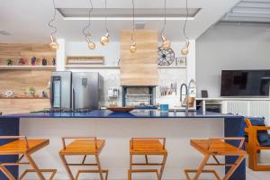 Una cocina con sillas de madera y una encimera azul. en ¡Bz 51 Centro! Alto estándar, 4 Suites con/ Zona de ocio privada, en Búzios