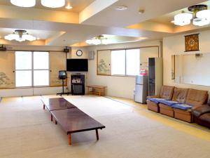 a living room with a couch and a table at Takasago Onsen in Asahikawa