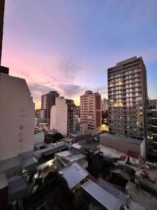 a view of a city at sunset with buildings at GRAN NIVEL EN El CENTRO DE NEUQUEN 1 DORMITORIO CON COCHERA OPCIONAL in Neuquén