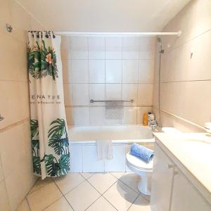 ein Badezimmer mit einer Badewanne, einem WC und einem Duschvorhang in der Unterkunft HABITACIONES con o sin baño privado, ESPACIOS semi privados o compartidos en DEPARTAMENTO COMPARTIDO, full equipado, primera fila, 2do piso, TERRAZA - PISCINA in Viña del Mar