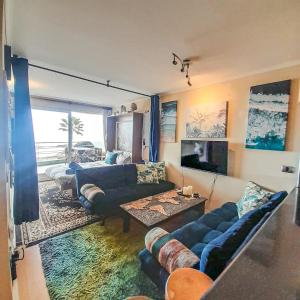 ein Wohnzimmer mit einem blauen Sofa und einem Tisch in der Unterkunft HABITACIONES con o sin baño privado, ESPACIOS semi privados o compartidos en DEPARTAMENTO COMPARTIDO, full equipado, primera fila, 2do piso, TERRAZA - PISCINA in Viña del Mar