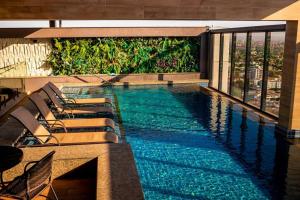 a swimming pool with lounge chairs on a building at Loft Aconchegante Centro in Dourados