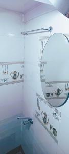 a bathroom with a glass shower with a mirror at The Aroma Backpackers in Mumbai +17 photos