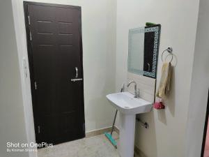 bagno con lavandino e porta nera di Serene Homestay Retreat a Bāzpur