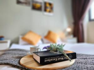a book on a wooden tray on a bed at M Centura Sentul KL Fully Air Con Blissful Suite KL in Kuala Lumpur