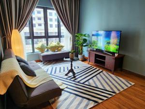 a living room with a couch and a tv at M Centura Sentul KL Fully Air Con Blissful Suite KL in Kuala Lumpur
