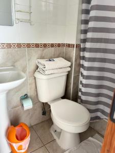 a bathroom with a white toilet and a sink at Hostal Avenue in La Serena