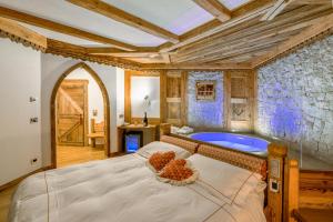 卡纳泽伊Chalet Pineta relax location的一间卧室设有一张大床和一个浴缸