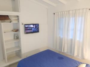 ein Schlafzimmer mit einem an der Wand hängenden TV in der Unterkunft Kuka 5 in Villa Gesell