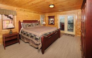 una camera con un letto in una baita di tronchi di Bear Tracks a Gatlinburg