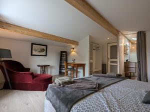 a bedroom with a large bed and a red chair at Gîte avec piscine chauffée, jardin clos et WiFi à Baignes - FR-1-653-264 in Baignes-Sainte-Radegonde +25 photos