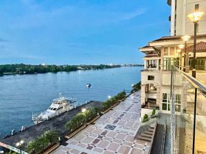 a boat on the river next to a building at Kuching City Center Riverine Apartment With Balcony and Garden View in Kuching