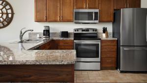 a kitchen with stainless steel appliances and wooden cabinets at Marriott Willow Ridge 2BD sleeps 8 in Branson +32 photos
