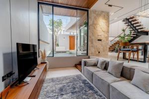 克罗柏坎Casa Estella Stunning 2BR in Umalas Canggu的带沙发和电视的客厅