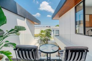 克罗柏坎Casa Estella Stunning 2BR in Umalas Canggu的阳台配有桌子和两把椅子