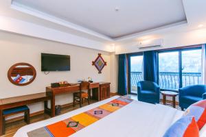 a hotel room with two beds and a desk and a television at Sapa Charm Hotel in Sapa