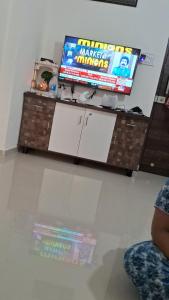 a living room with a tv and a table at Decent furnished 1RK Navi Mumbai in Taloje