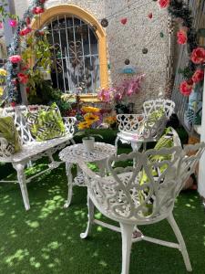 a patio with white chairs and a table and flowers at Apartamento acogedor in Sabana Grande