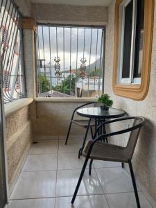 a table and a chair in a balcony with a window at Apartamento acogedor in Sabana Grande +3 photos