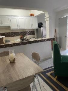 a kitchen with white cabinets and a wooden table at Apartamento acogedor in Sabana Grande