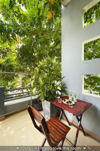une table et des chaises sur un balcon avec un arbre dans l'établissement FSTAY GARDEN CORNER - Cozy and Peaceful Homestay in Da Nang, à Đà Nẵng