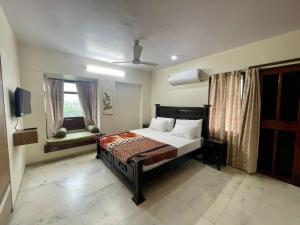 a bedroom with a bed and a window and a television at Aashvi homes - Rooms with Balcony in Jaipur