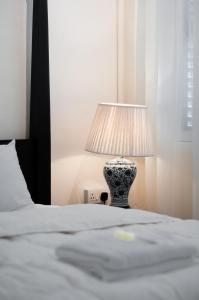 a vase sitting on a bed next to a lamp at Carnarvon Villa by Aayu George Town Penang in George Town