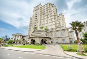 a large white building with a palm tree at The Cap Hotel in Vung Tau