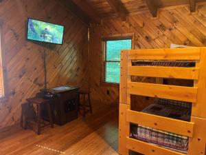 a log cabin with a bunk bed and a television at ER47 - Moody Blue - Great location, Close to all the action! cabin in Pigeon Forge