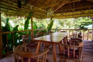 a wooden table and chairs on a porch at Moon's Thai Homestay in Ban Pa Mak (1)