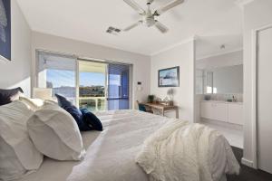 マンジュラにあるCanal Villa & Jetty-dolphin Views Walk-beachtownの大きなベッドと大きな窓のある寝室