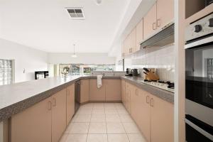 una grande cucina con armadi bianchi e piano di lavoro di Canal Villa & Jetty-dolphin Views Walk-beachtown a Mandurah Altre 77 foto