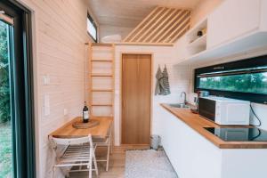 a tiny house with a kitchen and a table at La Voie Romaine by Tiny Away in Saint-Sébastien