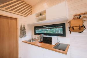 a kitchen in a tiny house with a microwave at La Voie Romaine by Tiny Away in Saint-Sébastien