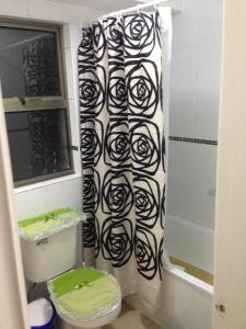 a bathroom with a black and white shower curtain at Mirador Villarrica Apartment in Villarrica