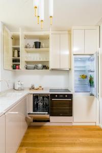 a kitchen with white cabinets and a black dishwasher at Mido Aviatie Park Apartments with Private Parking & Self Check-in in Bucharest +48 photos