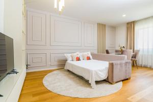 a white bedroom with a bed and a table at Mido Aviatie Park Apartments with Private Parking & Self Check-in in Bucharest