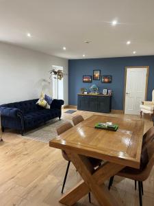 a living room with a blue couch and a wooden table at Unique countryside stay in Dundrod