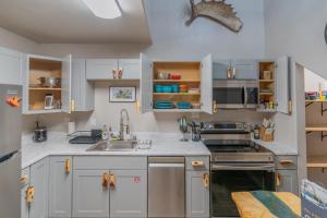 a kitchen with white cabinets and a sink at Central Driftwood 2.0 in North Pole