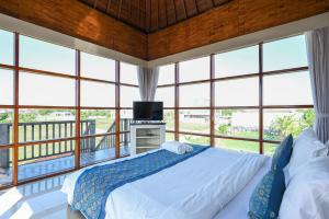 Un dormitorio con una cama y grandes ventanales. en Hoki Villa by Urbanview Villa, en Kerobokan 61 fotos más