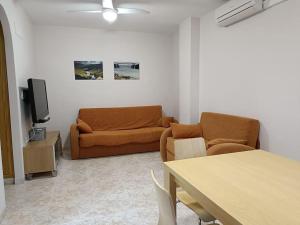 a living room with a couch and a tv at Galatea Arena in Arenales del Sol +10 photos
