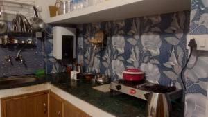a kitchen with a counter top with a pot on a stove at Fruit Bowl in Rāmgarh