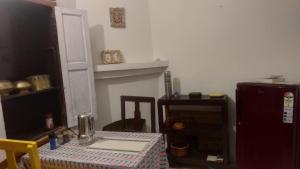 a dining room with a table and a refrigerator at Fruit Bowl in Rāmgarh +5 photos