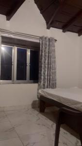 a bedroom with a bed and two windows at Fruit Bowl in Rāmgarh