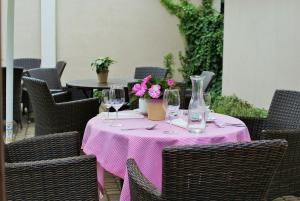 a pink table with glasses and flowers on it at Gościniec Sucholeski in Suchy Las