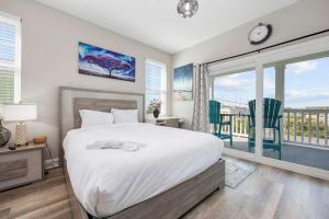 a bedroom with a large bed and a balcony at DERBY BLUE A- Ocean Views- Garage & EV Charger in Myrtle Beach
