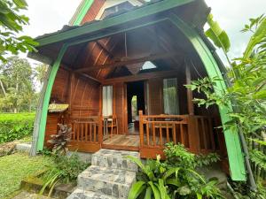 a wooden house with a porch and a deck at Rumah Kayu Leke - Leke Guesthouse in Tegalalang