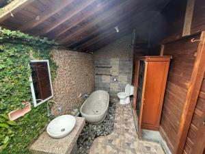 a bathroom with a sink and a toilet at Rumah Kayu Leke - Leke Guesthouse in Tegalalang