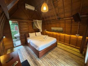 a bedroom with a bed in a wooden room at Rumah Kayu Leke - Leke Guesthouse in Tegalalang